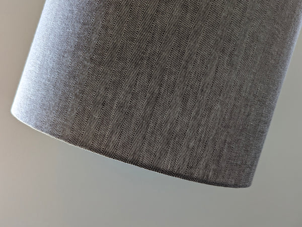 Close-up of a textured brown herringbone fabric on a neutral background