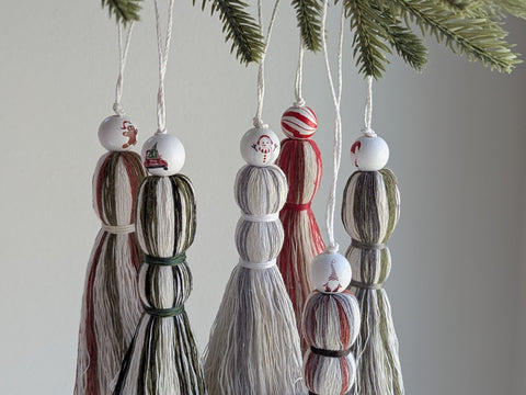 Decorative tassel ornaments hanging from a Christmas tree.