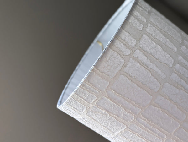 close up of textured paper lamp shade in a drum shape with a geometric pattern