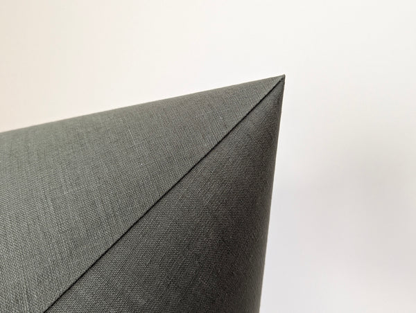 close up of the top detail of the back seam of the cone shaped lamp shade in olive green linen