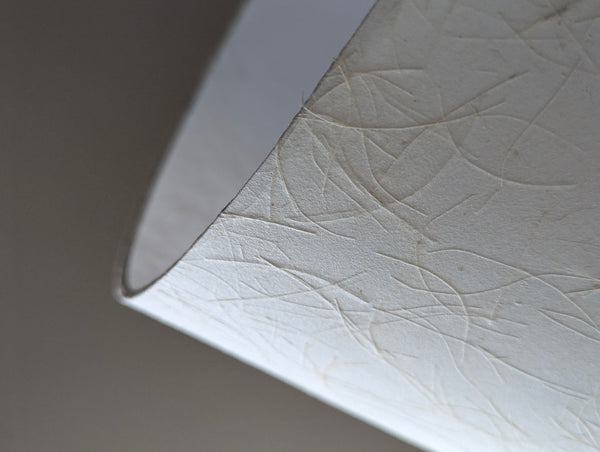 close up of the edge detail of a paper lamp shade with textured surface