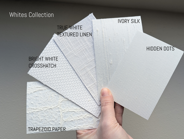 Hand holding samples of textured white lamp shades labeled 'Whites Collection' on a gray background.