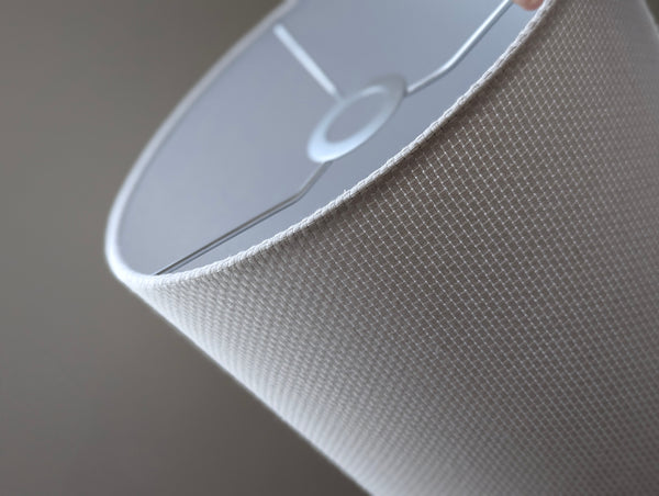 Close-up of a white textured lampshade in Bright White Crosshatch fabric against a soft gray background
