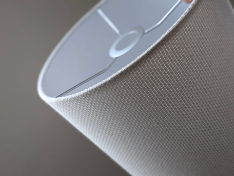 Close-up of a white textured lampshade in Bright White Crosshatch fabric against a soft gray background