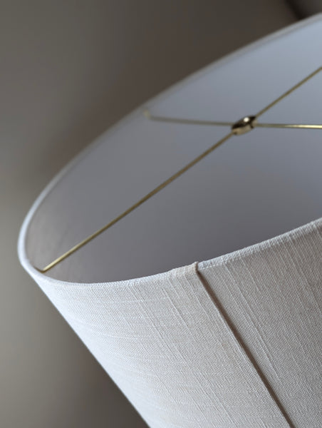 Close-up of a drum lampshade made of white linen fabric with spider washer hardware