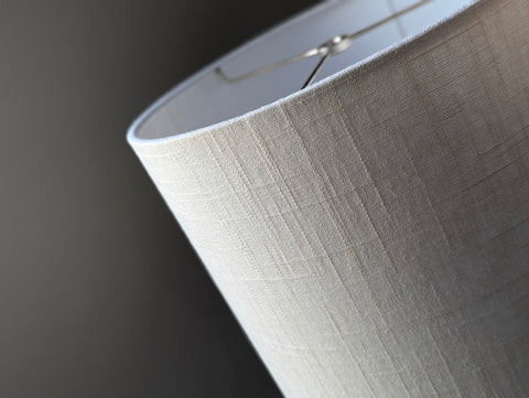 Close-up of a drum lampshade made of white linen fabric with spider washer hardware