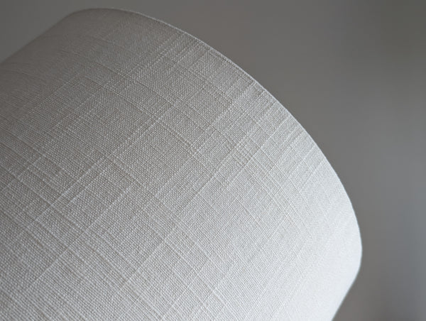 Close-up of a drum lampshade made of white linen fabric