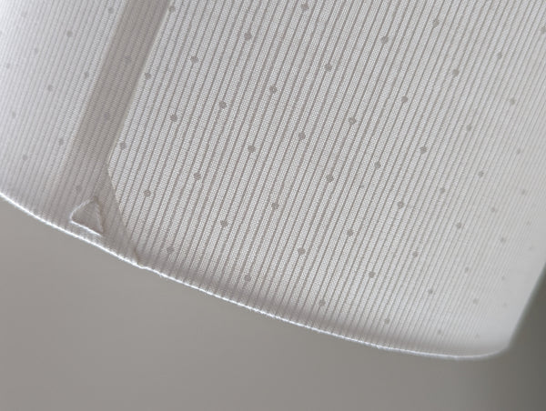 close up of white lamp shade with a triangle stitch detail in back seam