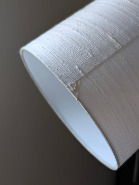 Close-up of a textured white lampshade on a dark background