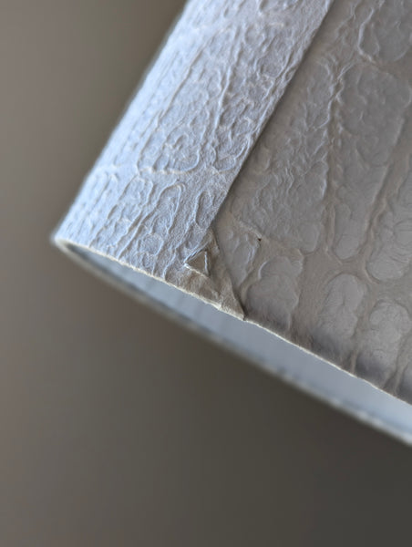 close up of the back seam of a paper lamp shade showing the signature triangle stitch detail of Ud Form lamp shades