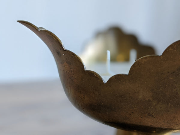 close up of scalloped edge on vintage brass candle