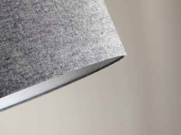 close up of bottom wrapped edge of fabric lamp shade showing the black and white woven fabric