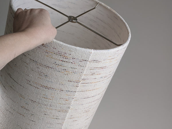 hand holding a Confetti handwoven fabric lamp shade with nickel hardware