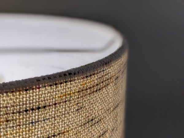 close up image of woven fabric lamp shade to see how the light looks shining through the fabric fibers