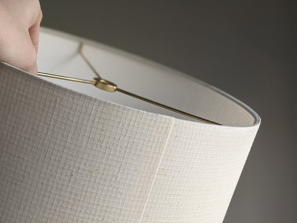hand holding brass hardware of a handmade lamp shade in Grid Ecru fabric by Ud Form