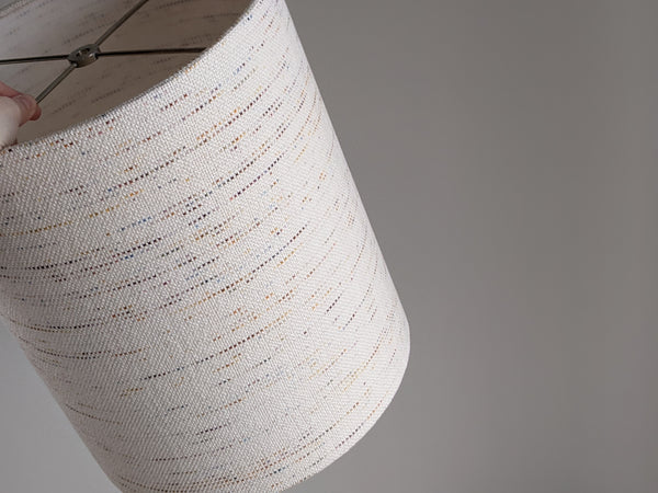 a long narrow lamp shade in Handwoven Confetti Fabric with nickel hardware