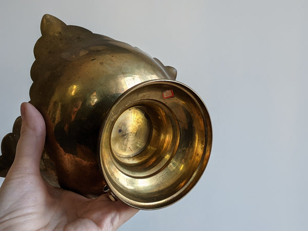close up shot of the bottom of a brass pedestal candle