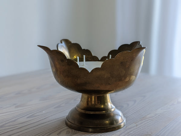 flower-shaped vintage brass candle sitting on a table
