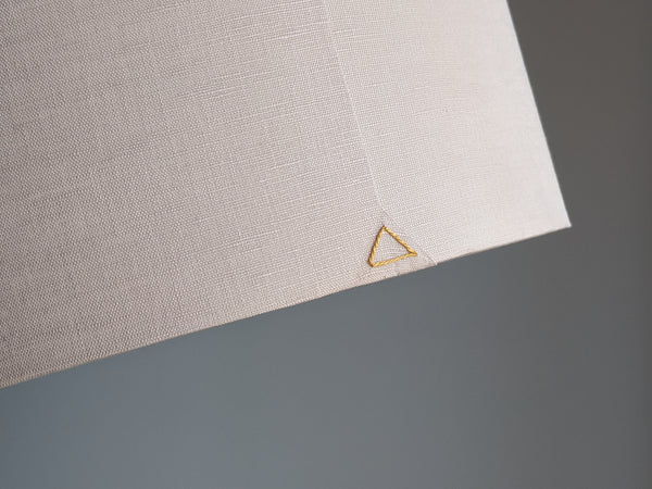 Close up of gold triangle stitch detail on seam of handmade lamp shade in blush.