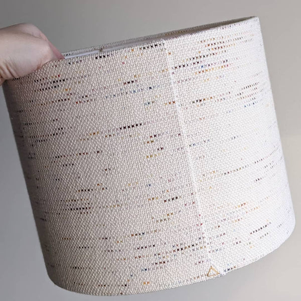 hand holding a Confetti fabric lamp shade showing the back seam and stitch detail