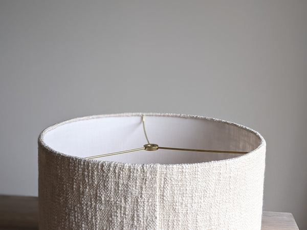 close up of edge and seam details on the back of a cream colored, handwoven fabric lamp shade